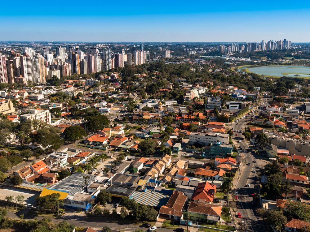 Vista aérea de Curitiba cidade modelo, destacando bairros planejados, infraestrutura urbana e qualidade de vida.