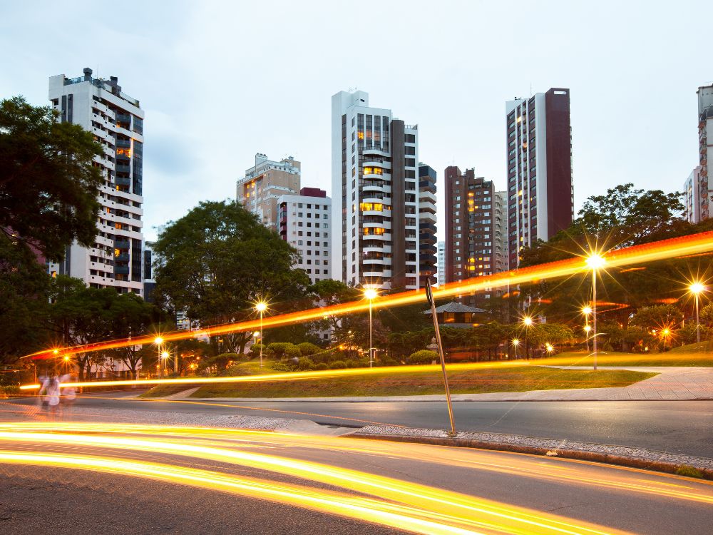 Paisagem noturna de Curitiba cidade modelo, com edifícios modernos, iluminação urbana e mobilidade eficiente.
