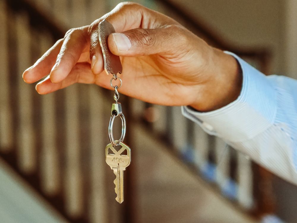Investidor segura chave de imóvel, reforçando que comprar apartamento para alugar é um bom investimento para gerar renda passiva.