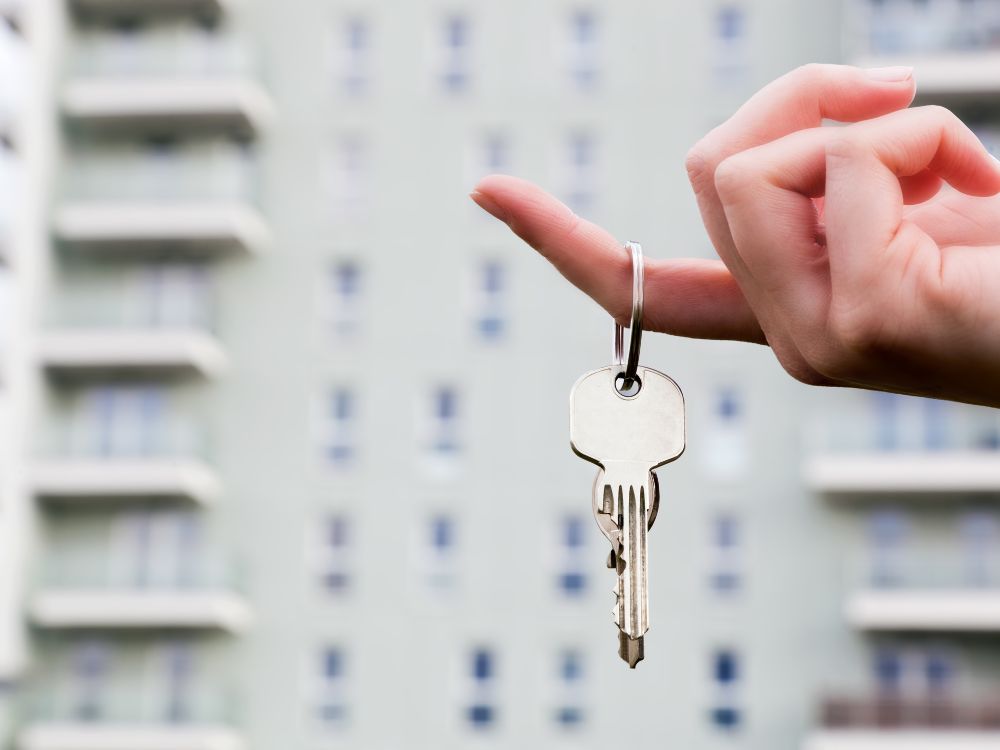 Sucesso ao comprar para alugar em Curitiba simbolizado por chave de apartamento e edifício residencial com alta liquidez.