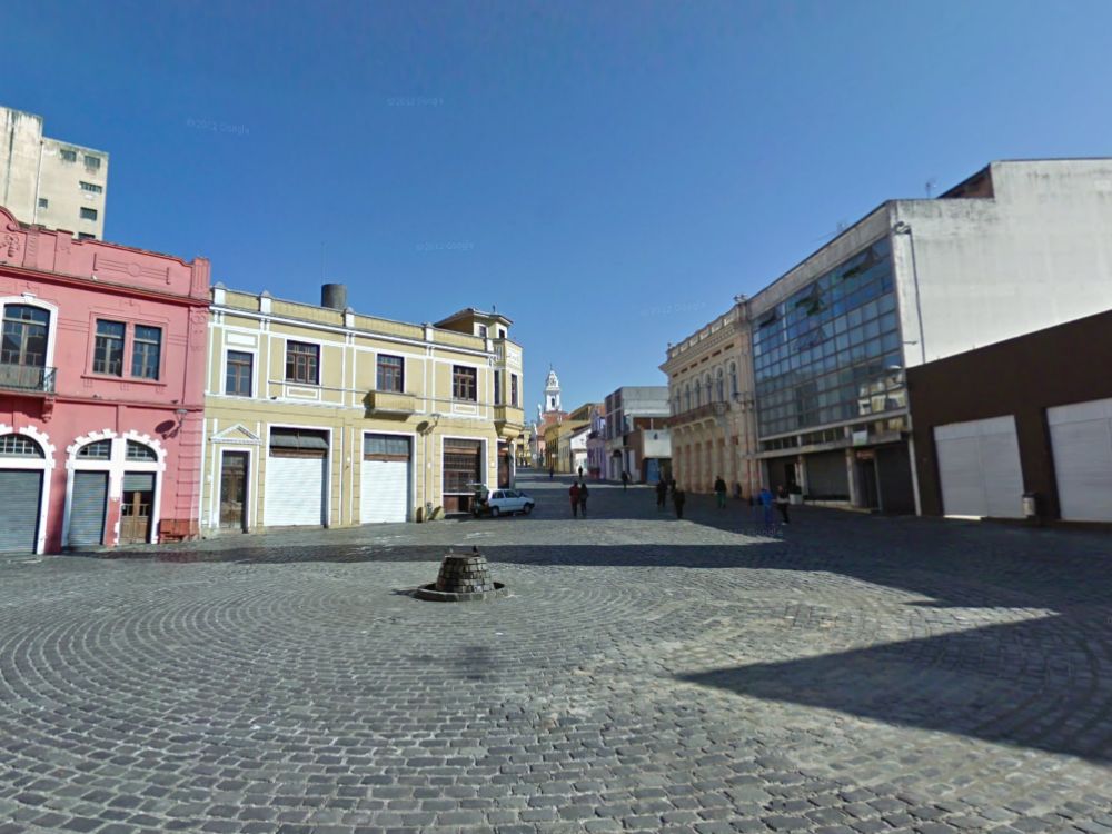 Fachadas históricas com ruas de paralelepípedo no setor histórico de Curitiba, ideal para retrofit e projetos de valorização imobiliária.