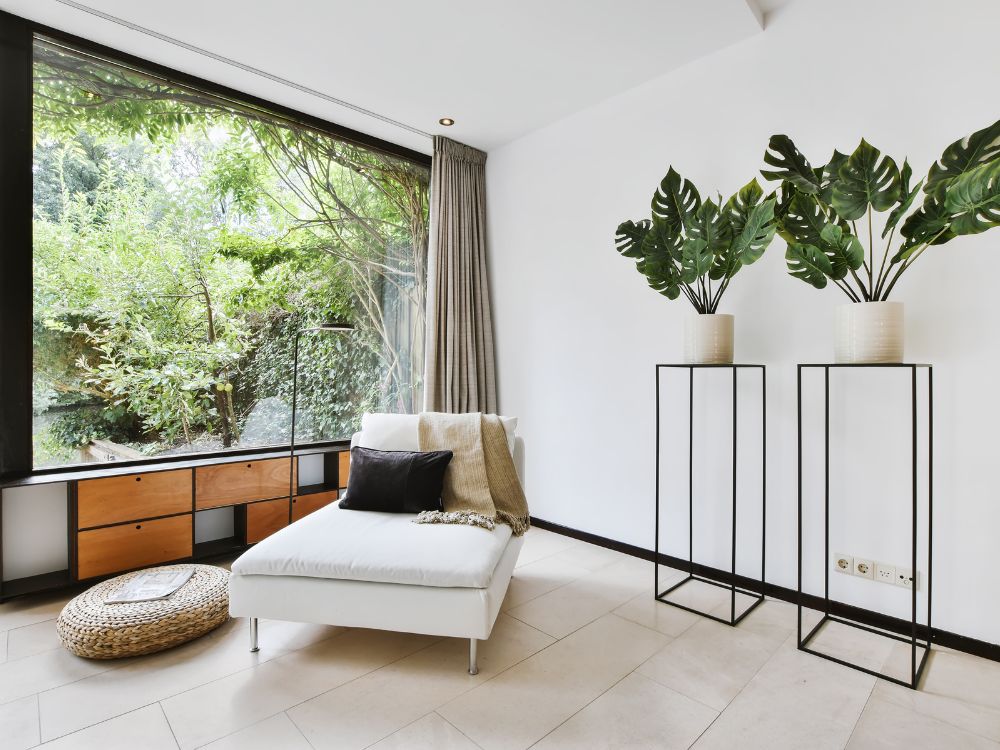 Sala com design minimalista, vista para o jardim e decoração clean representa o novo luxo com foco em privacidade e bem-estar.