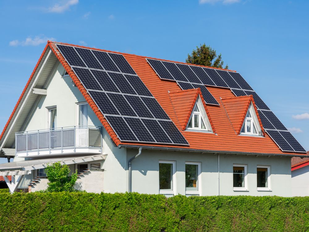 Telhado de casa com painéis solares reforça a sustentabilidade como valor essencial no conceito de novo luxo no mercado imobiliário.