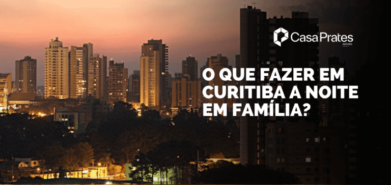 Vista noturna de Curitiba, com os edifícios iluminados ao fundo e a cidade em transição do entardecer para a noite, oferecendo diversas opções de lazer em família.