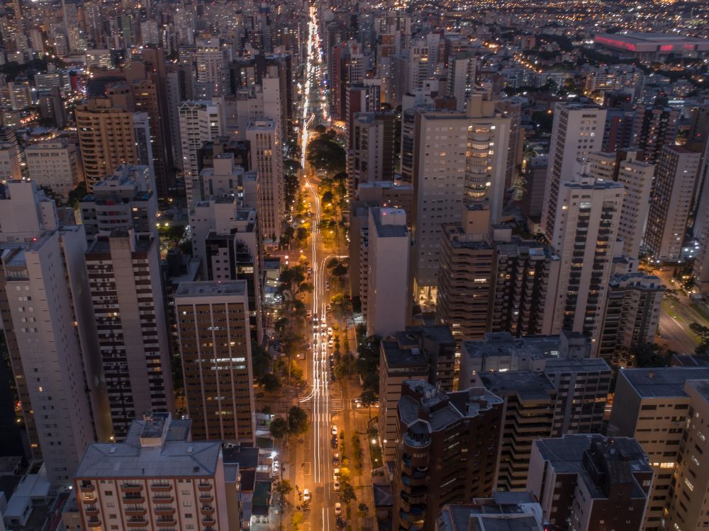 Imagem aérea de Curitiba à noite, destacando a movimentação nas ruas e a beleza da cidade iluminada. Confira o que fazer em Curitiba a noite coma familia.
