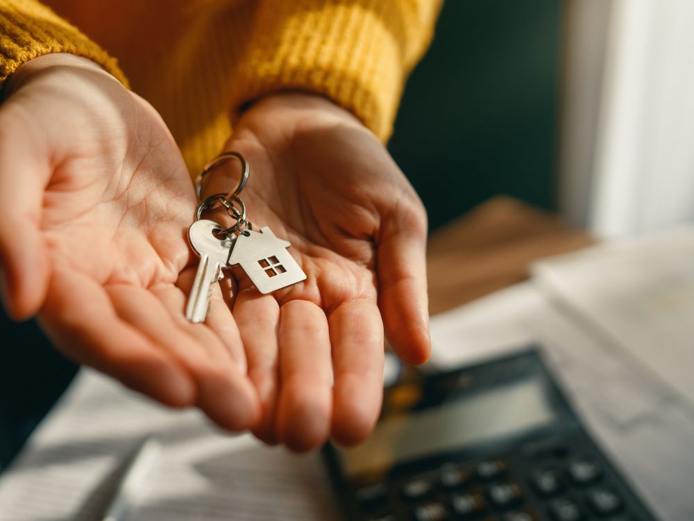 Entrega de chaves de imóvel com simbolismo de conquista e aquisição, imagem relacionada ao que faz a imobiliaria na finalização da compra