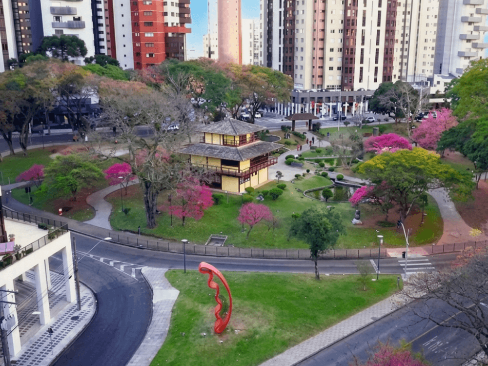 Vista do bairro Água Verde em Curitiba com praça arborizada, edifícios residenciais e espaços de lazer em uma região valorizada.