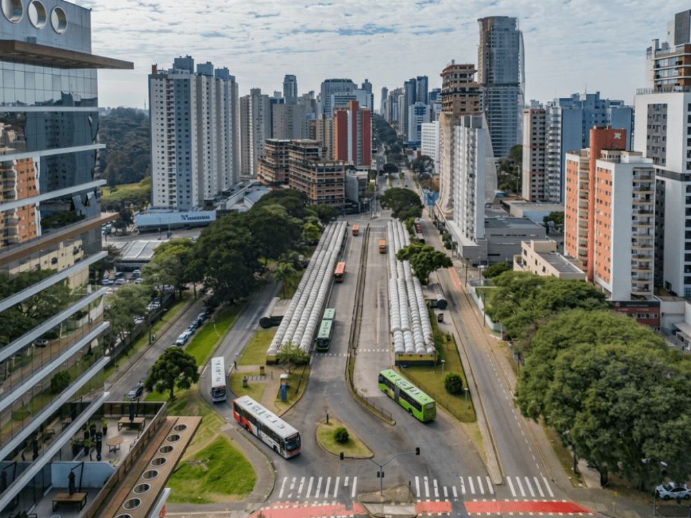 Corredor de ônibus cercado por edifícios e vias urbanas no bairro Campina do Siqueira em Curitiba.