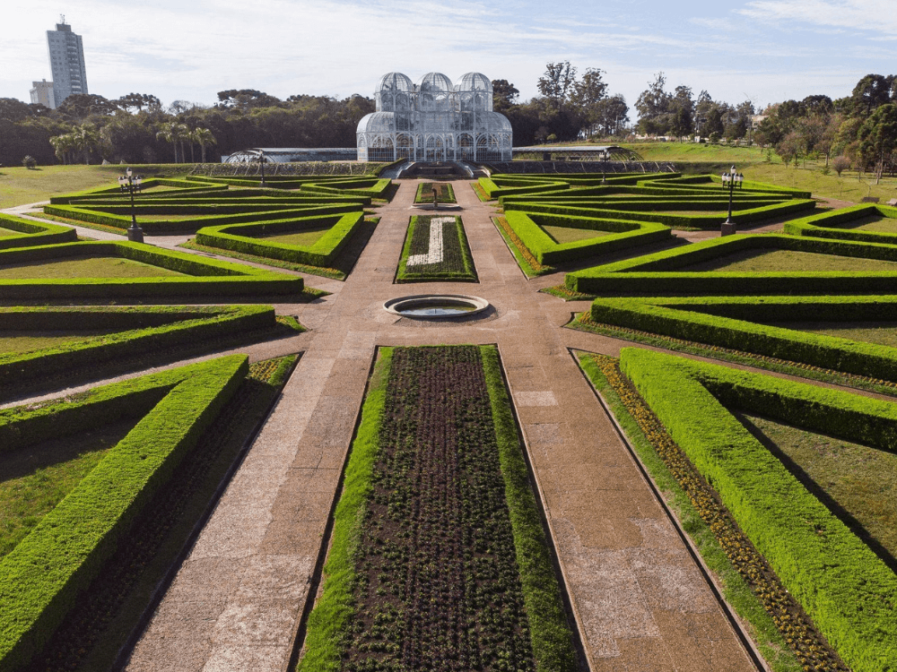 Jardins geométricos e estufa de vidro em área verde do bairro Cristo Rei, um dos destaques de Curitiba.