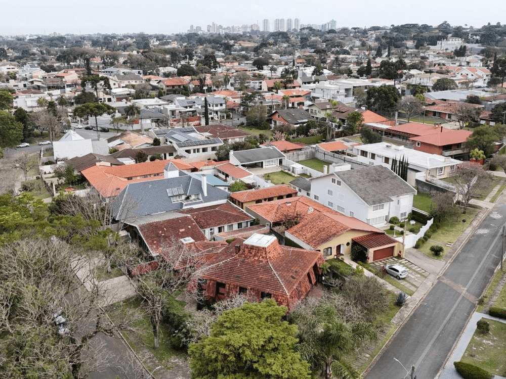 Vista aérea de ruas residenciais com casas e jardins no bairro Jardim Social em Curitiba.