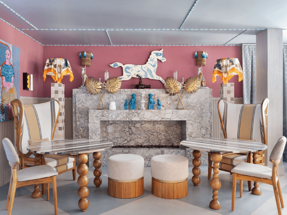 Sala de jantar com peças decorativas, revestimentos em mármore e elementos artísticos expostos na CASACOR Paraná.